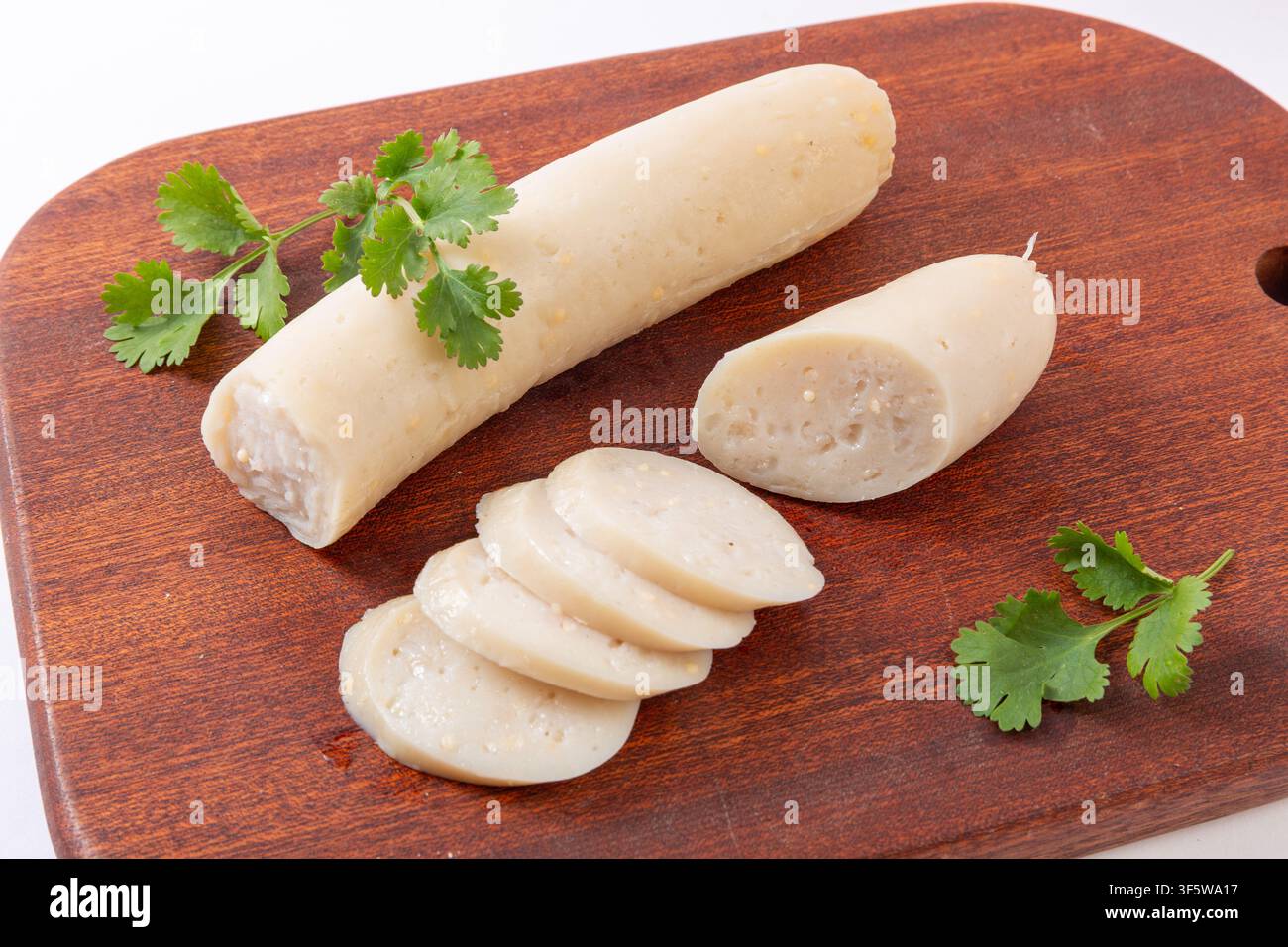 Salsicce di pollo con uova di pesce volante cotte su tagliere di legno Foto Stock