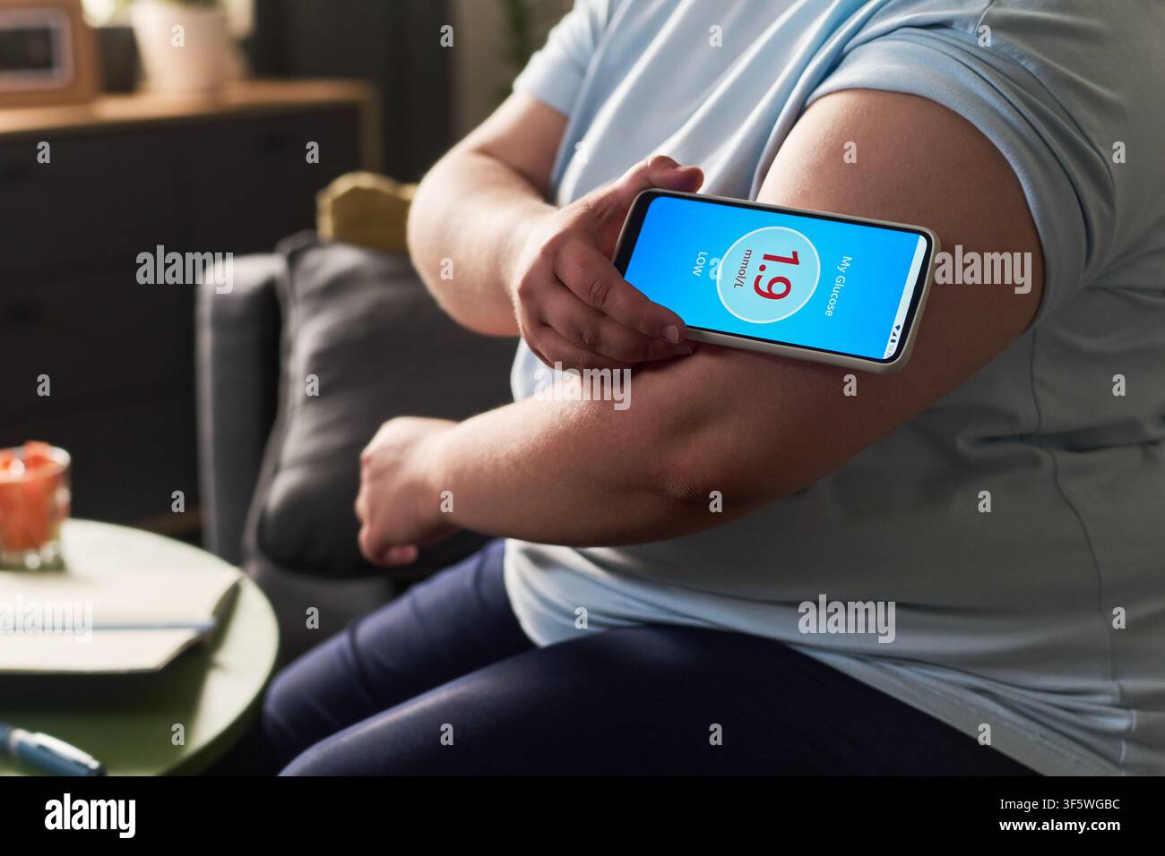 Donna che scansiona un monitor continuo della glicemia con un'app per smartphone Foto Stock