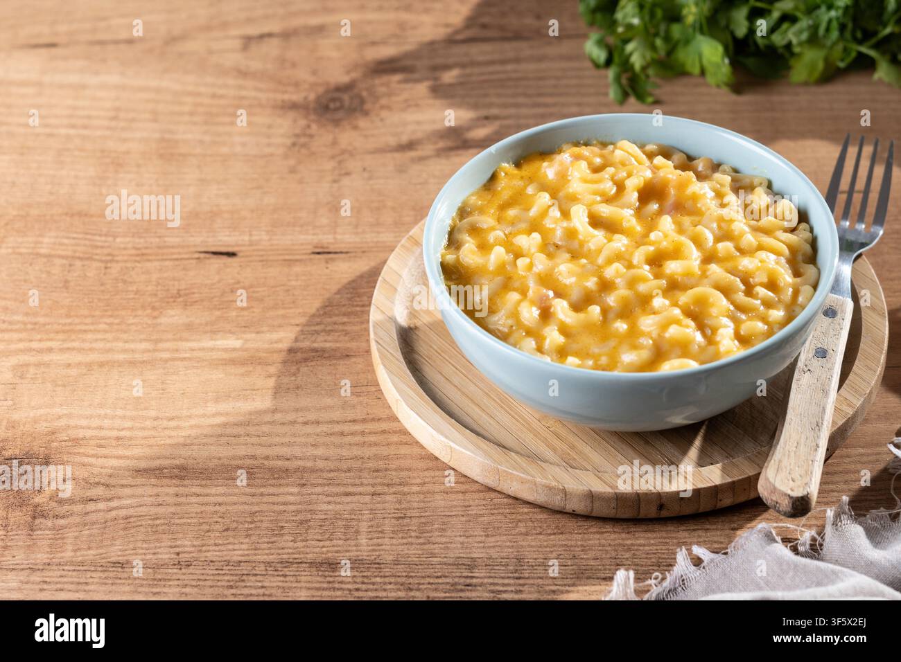 Mac e formaggio cremoso in una ciotola su un tavolo di legno Foto Stock