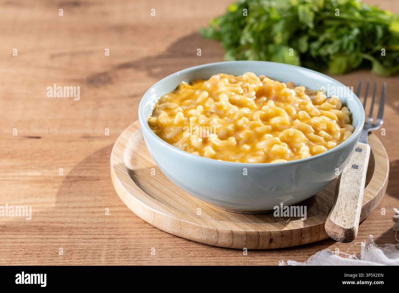 Mac e formaggio cremoso in una ciotola su un tavolo di legno Foto Stock