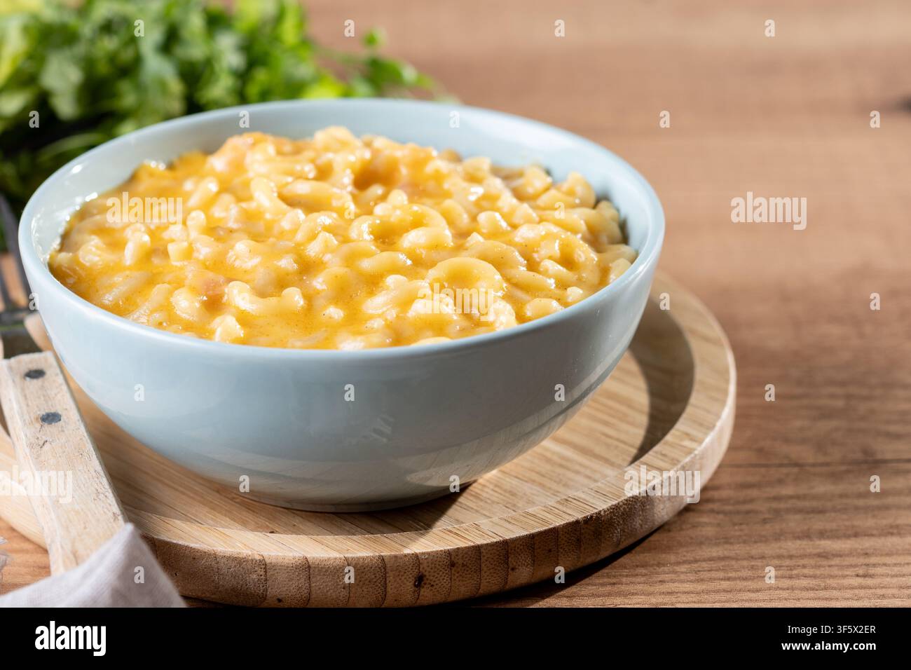 Mac e formaggio cremoso in una ciotola su un tavolo di legno Foto Stock