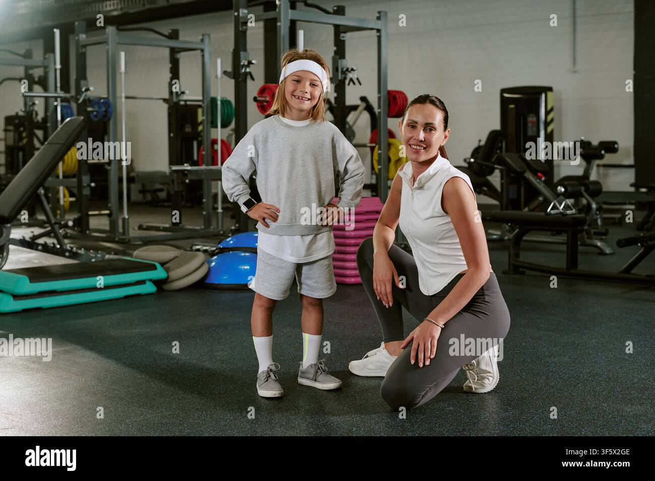 Ritratto di un'allenatrice e di un bambino che sorride in palestra Foto Stock