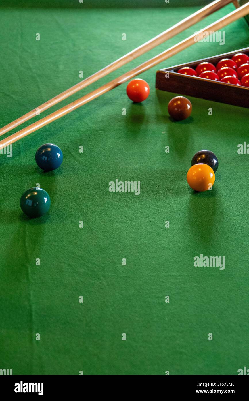 Tavolo da snooker con stecche e palle colorate su feltro verde pronto per una partita di biliardo Foto Stock