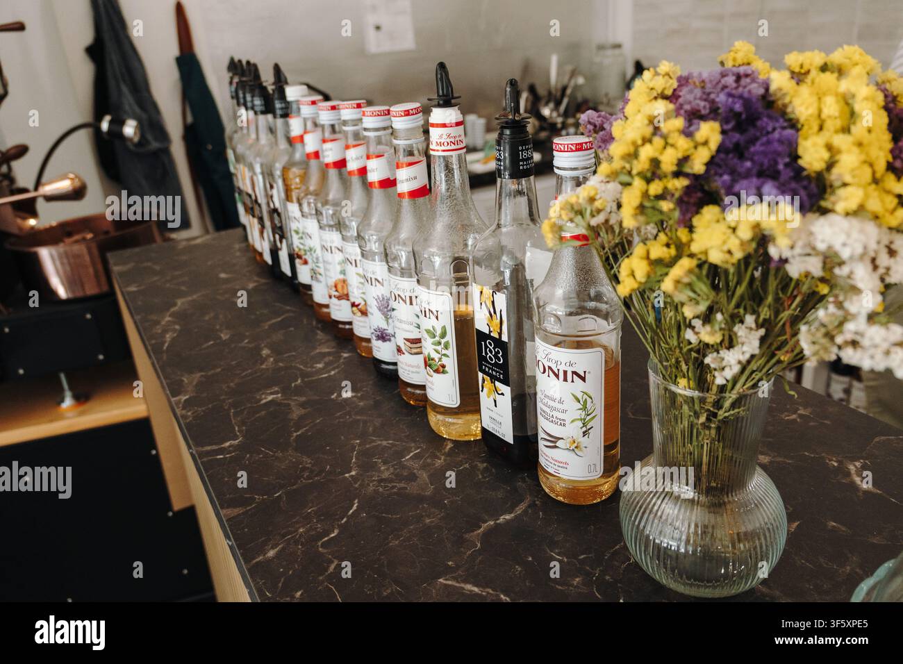 Belgrado, Serbia - 29 luglio 2026. Bottiglie di sciroppi aromatizzati Monin e 1883 disposte su un bancone del caffè, che mostrano una selezione di ingredienti per bevande Foto Stock