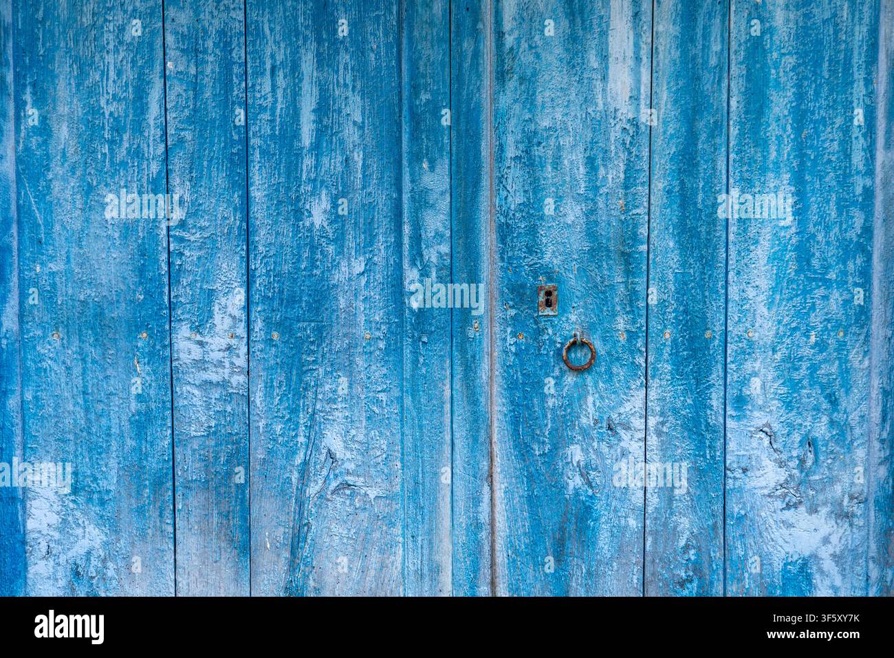 Antica porta invecchiata nel tempo in legno naturale dipinto di blu intenso Foto Stock