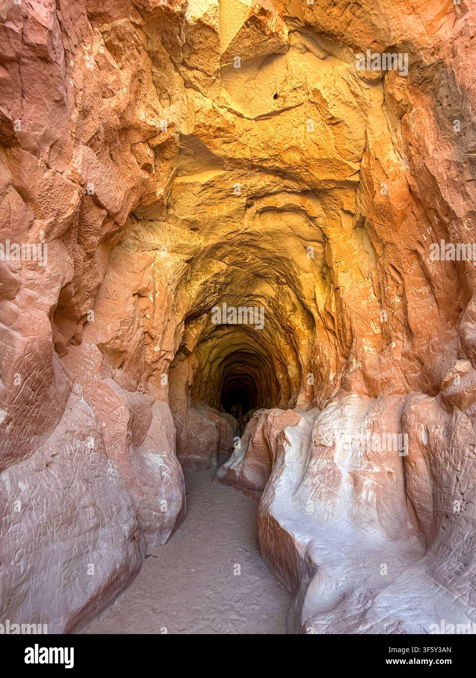Ingresso al sentiero escursionistico attraverso il Ventre del Drago vicino a Kanab, che è un tunnel di drenaggio artificiale con rocce di arenaria levigate dall'acqua - Immagine stock catturata con smartphone