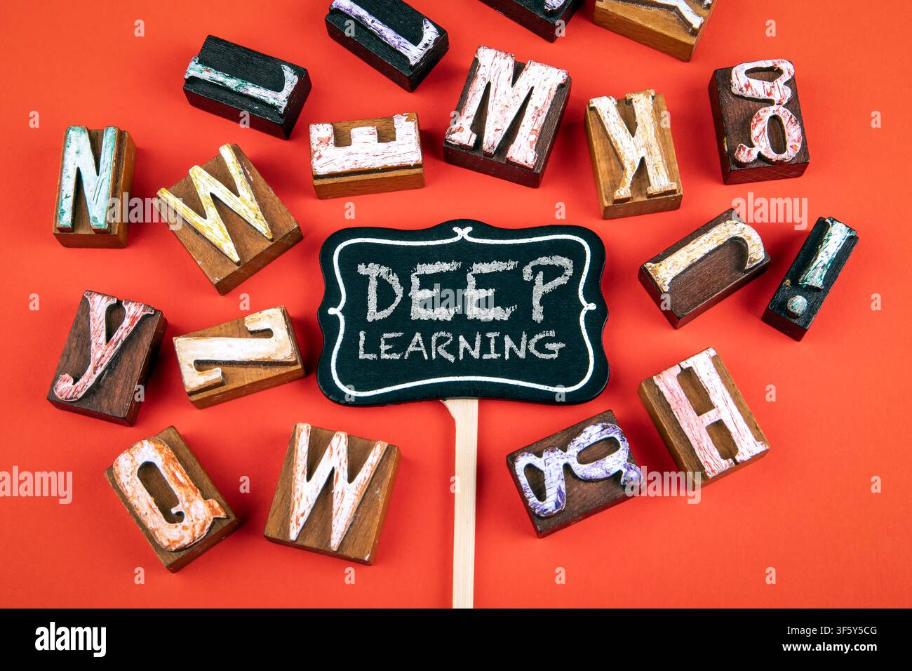 Messaggio di Deep Learning visualizzato su una piccola lavagna con lettere di legno su sfondo rosso Foto Stock