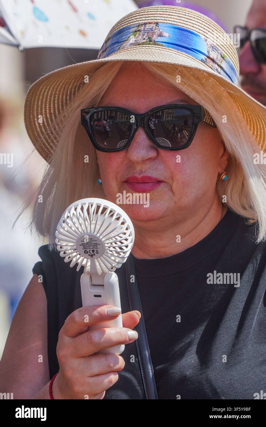 4 agosto 2026 Donna che tiene un ventaglio portatile manuale Foto Stock