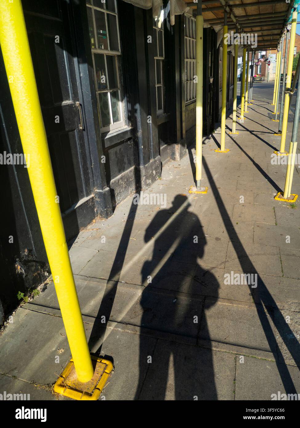 Gazzelle e ombre – compresa la mia – creano geometrie astratte con un sole basso di mezza estate. Questo restauro edilizio si trova in Ock Street, la via principale commerciale e principale della storica città di Abingdon, nell’Oxfordshire. Foto Stock