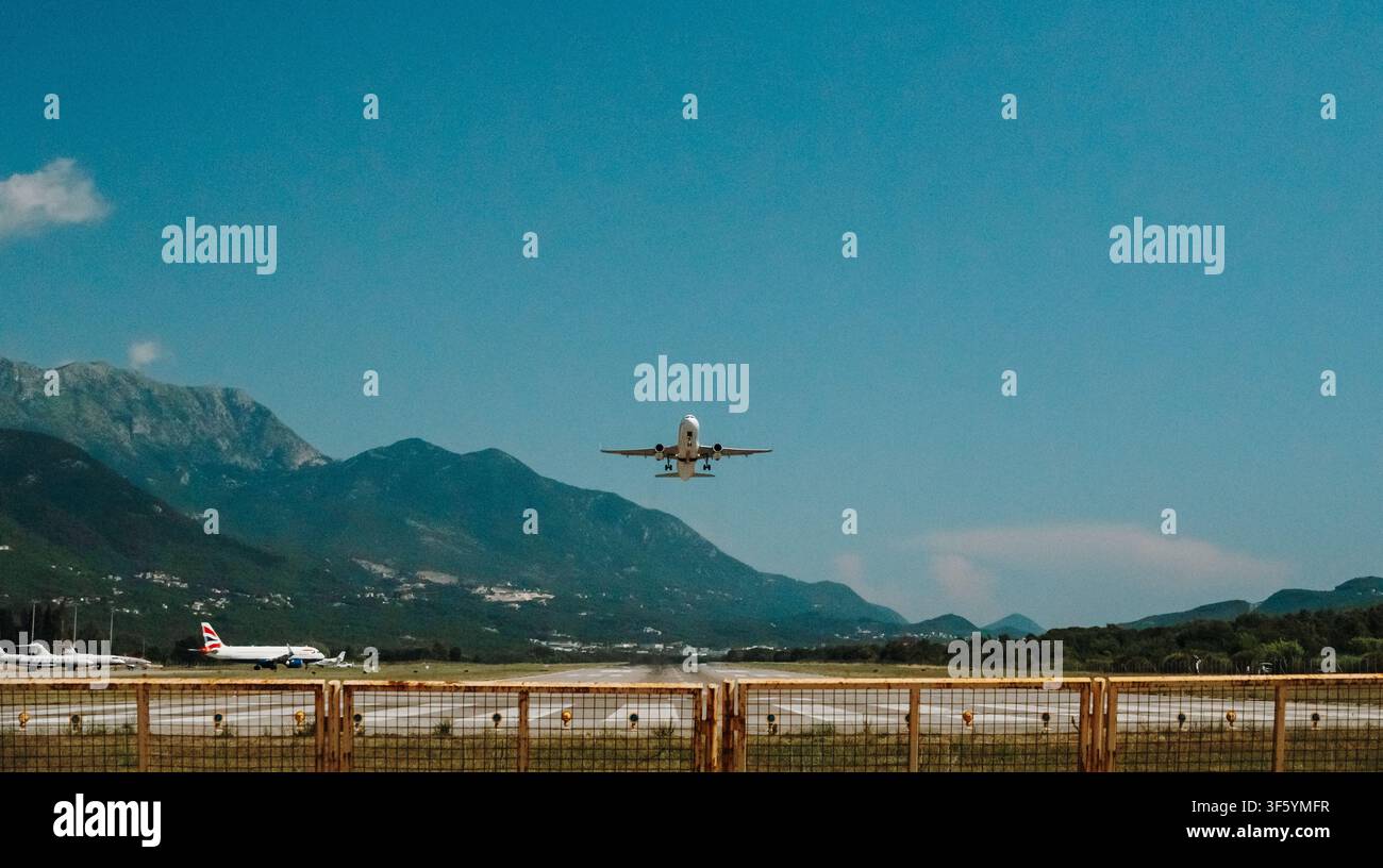 Tivat, Montenegro - 25 giugno 2026. Un aereo passeggeri si avvicina alla pista per l'atterraggio all'aeroporto di Tivat con montagne sullo sfondo. Foto Stock