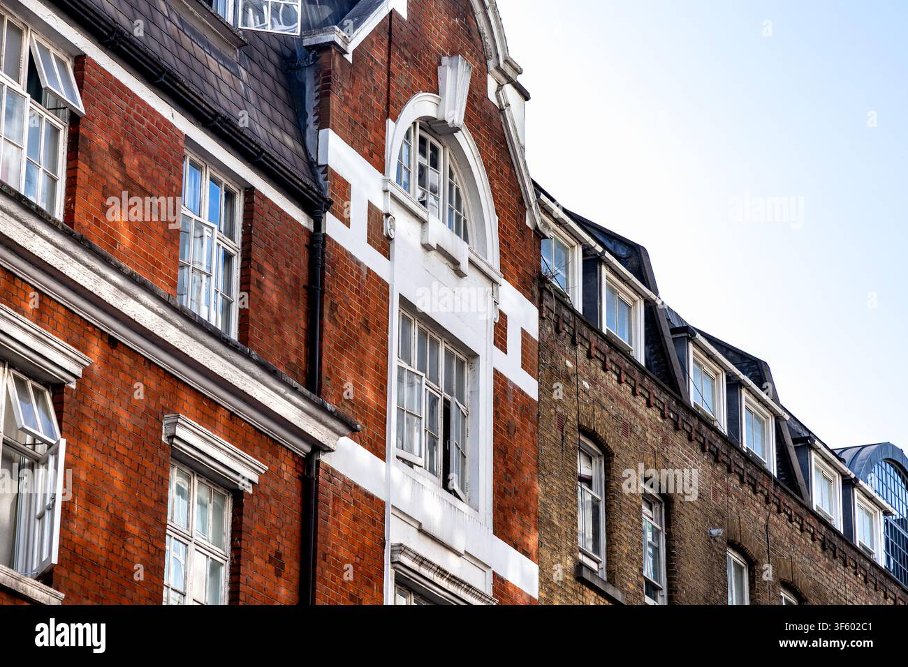 Edifici residenziali tradizionali in mattoni rossi e in stile vittoriano con dettagli architettonici bianchi lungo una strada a Londra, Inghilterra, Regno Unito Foto Stock