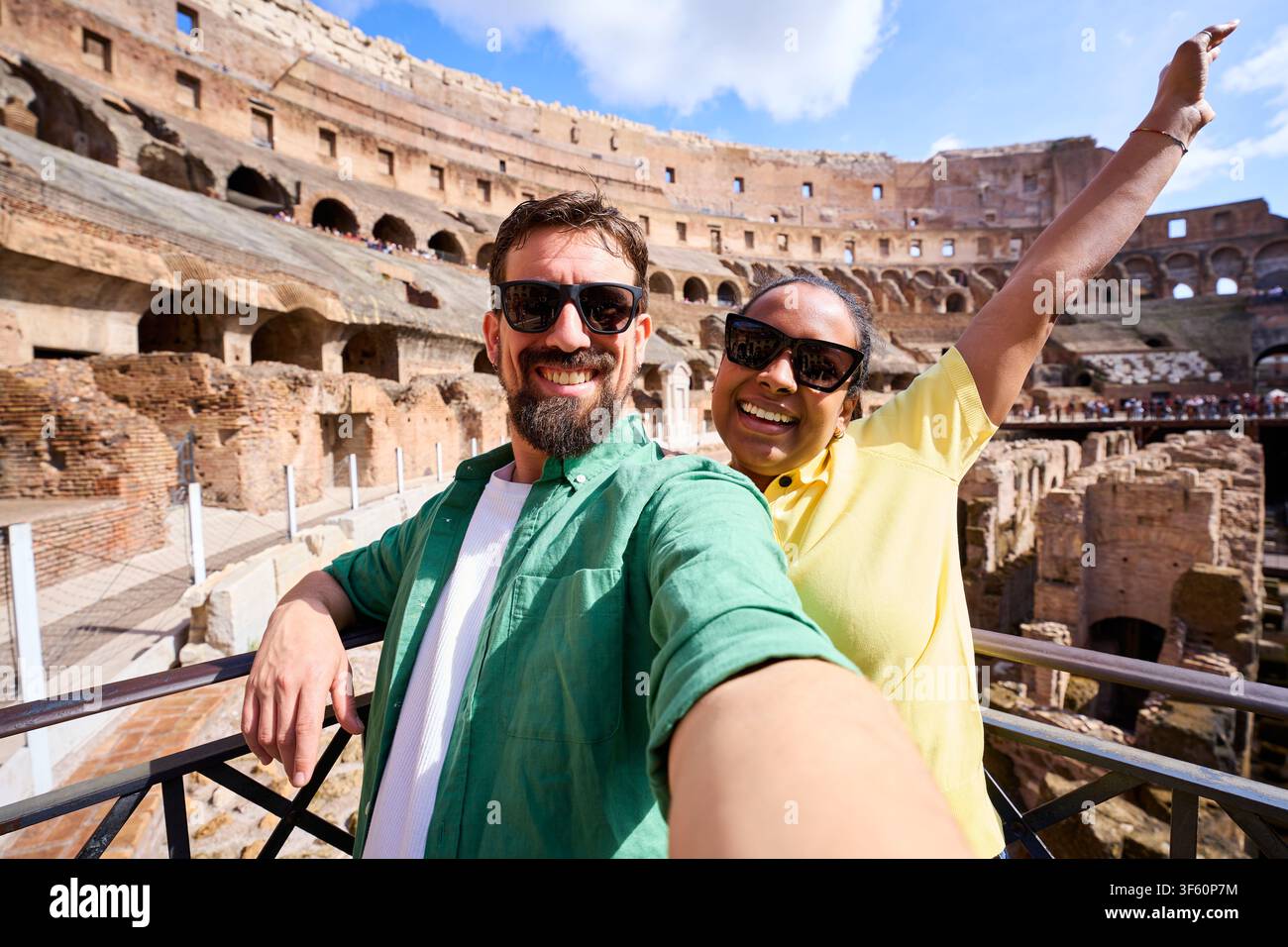 Coppia sorridente che fa un selfie con il colosseo in sottofondo durante la loro vacanza romana Foto Stock