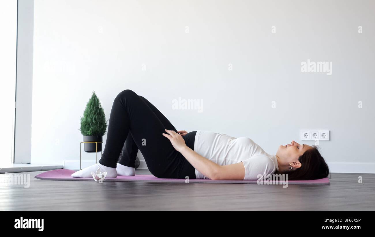 Donna incinta che pratica yoga prenatale per il fitness e il benessere Foto Stock