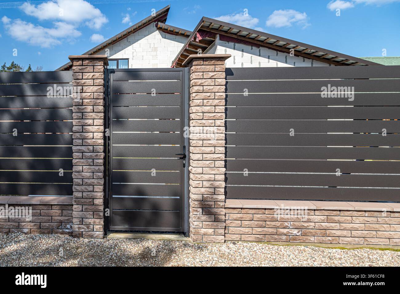Recinto e cancello moderni di una casa di campagna. Concetto di sicurezza, immobiliare periferico e ristrutturazione di qualità. Foto Stock