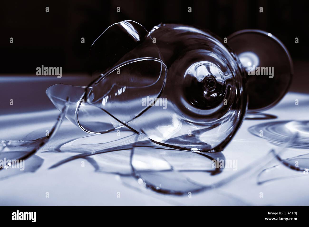 Calice rotto con ombre blu che simboleggiano rischio e incertezza Foto Stock