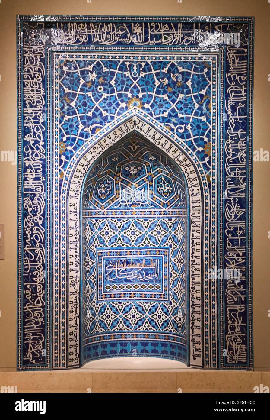 Una nicchia di preghiera (mihrab) in mosaico di piastrelle smaltate del XIV secolo da Isfahan, Iran, con motivi arabescati blu e bordi calligrafici in mostra. Foto Stock