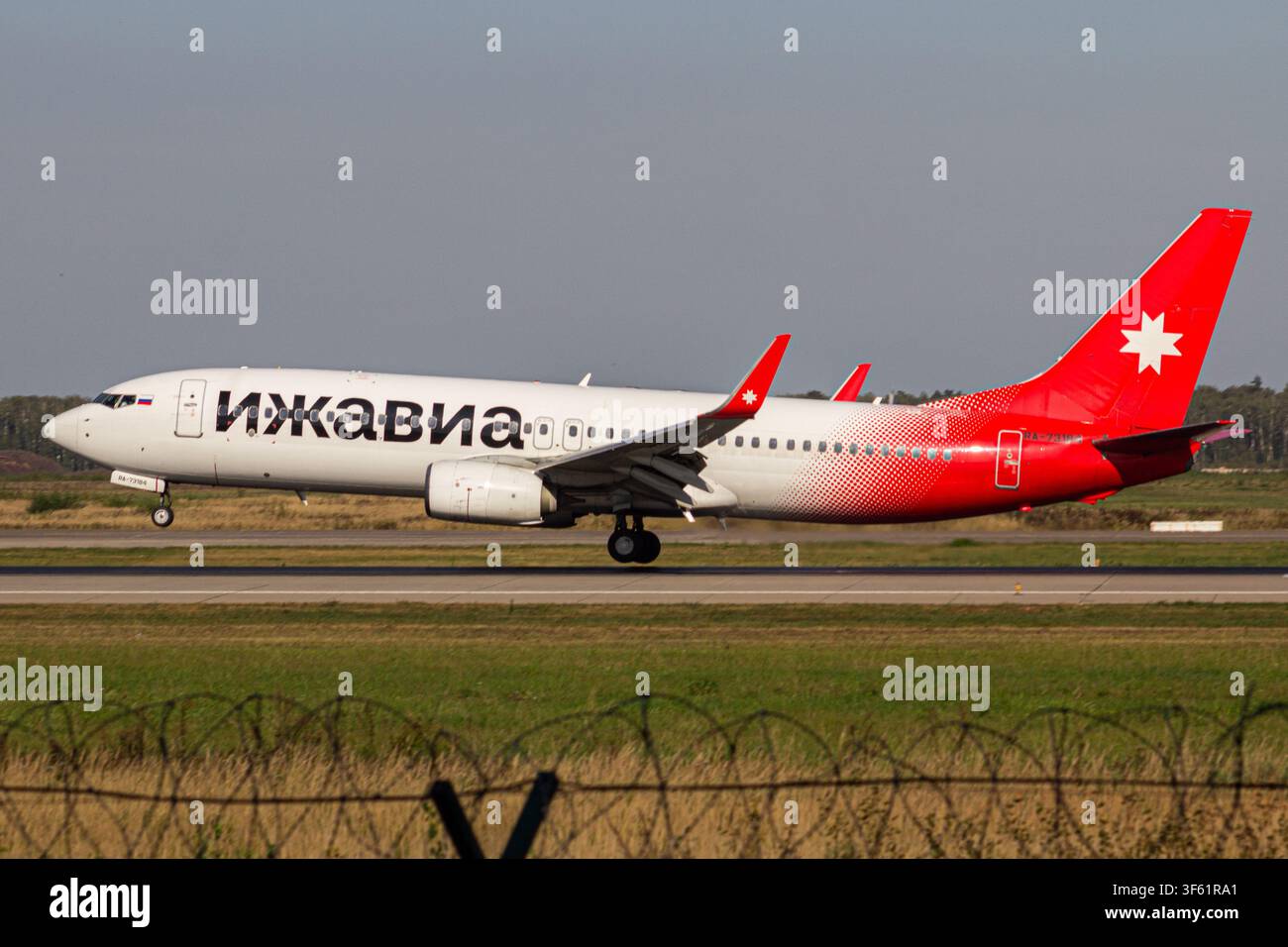 Aereo passeggeri Izhavia che si taxa lungo la pista in una giornata soleggiata Foto Stock