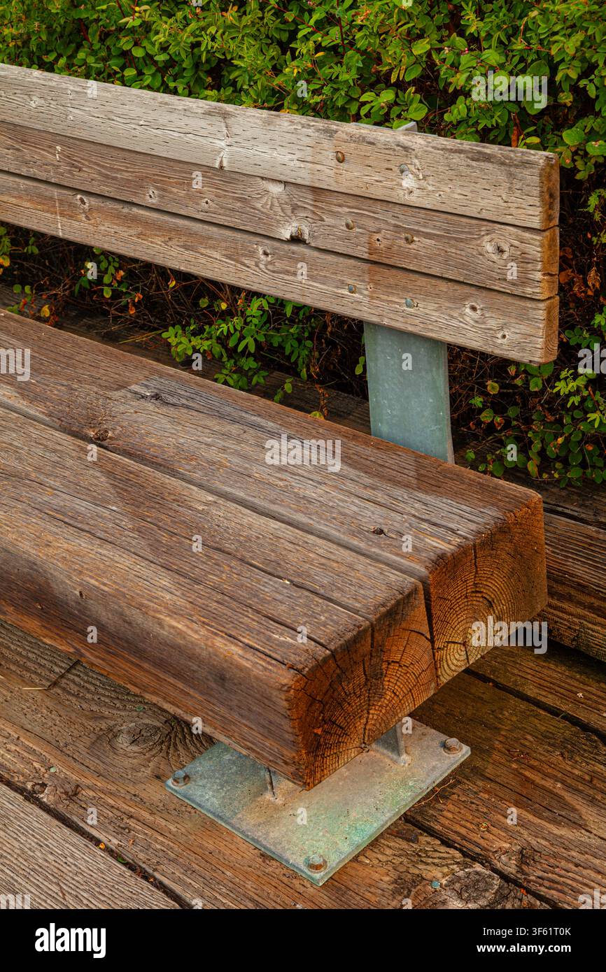 Panchina pubblica con ampie travi di legno come seduta Foto Stock