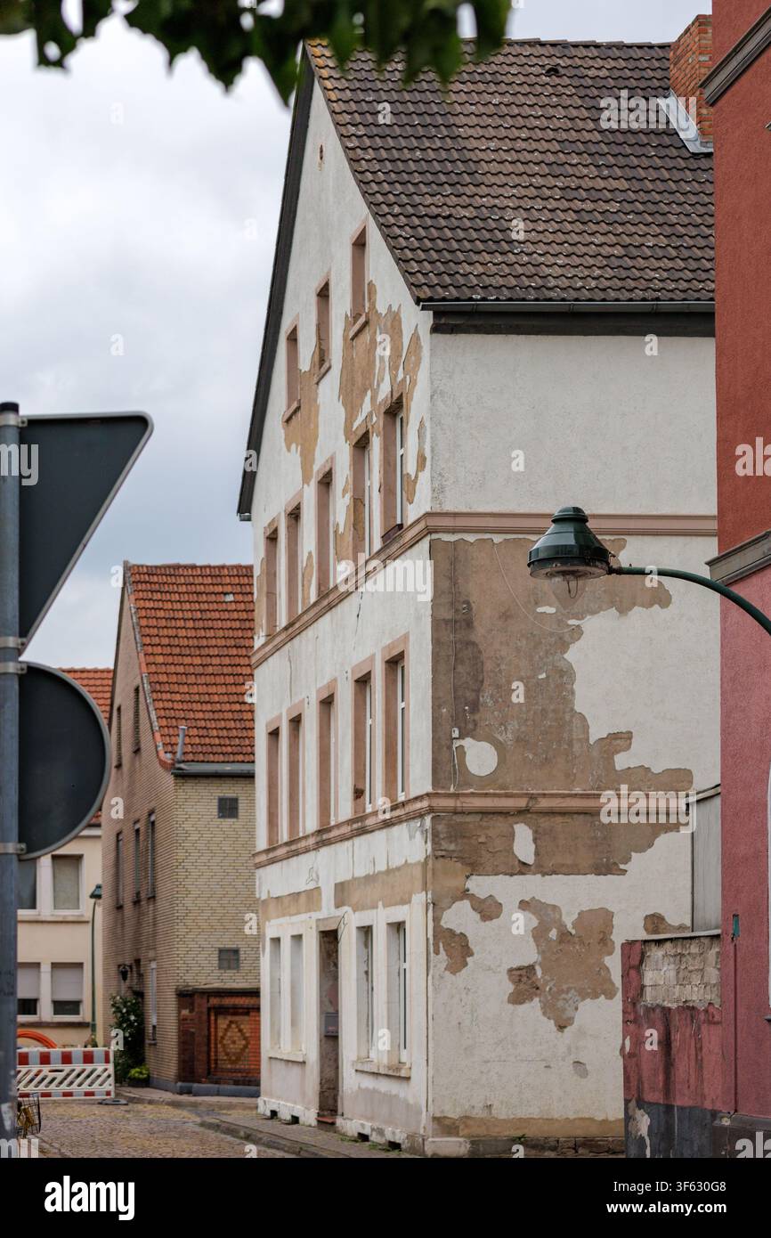 Facciata di edificio residenziale erosa con intonaco screpolato in una strada del centro storico Foto Stock