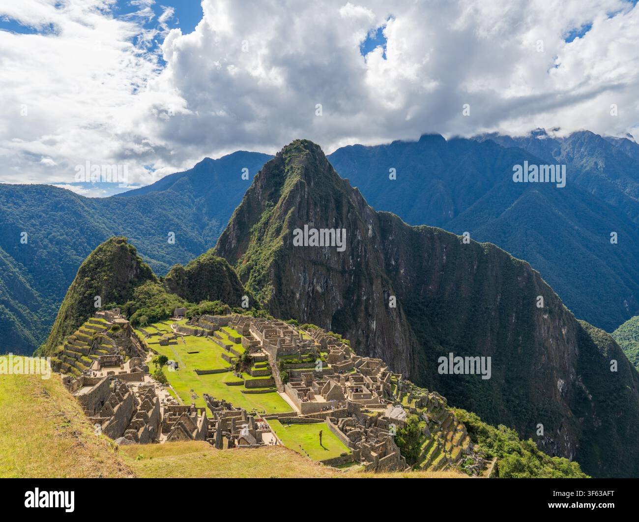 Antiche rovine in pietra della cittadella Inca Machu Picchu che si estendono su una cresta montuosa sotto il picco Huayna Picchu nelle Ande peruviane Foto Stock