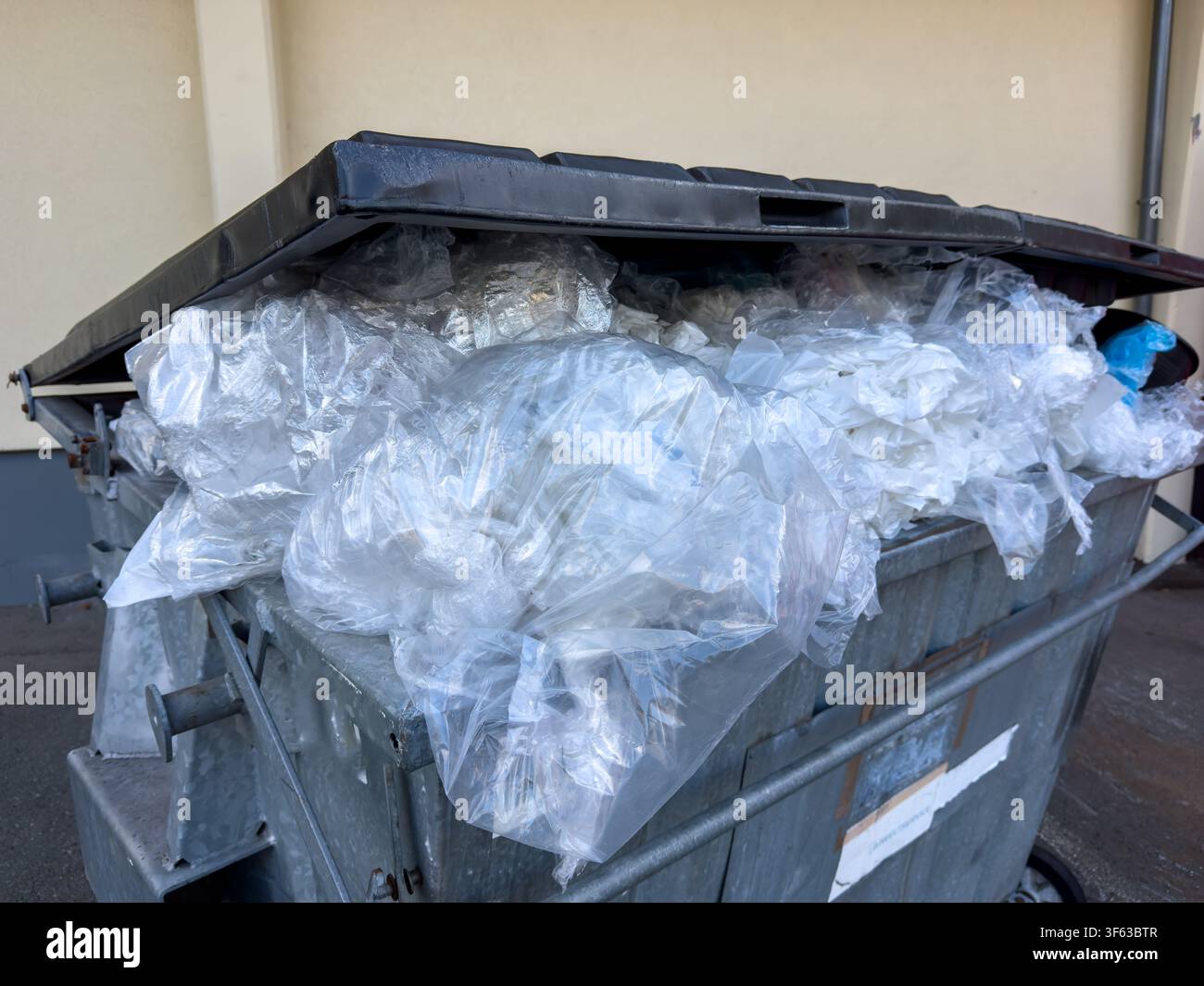Cestino nero pieno di rifiuti di plastica, pellicola di plastica e PVC – Concetto di riciclo della plastica e gestione dei rifiuti Foto Stock