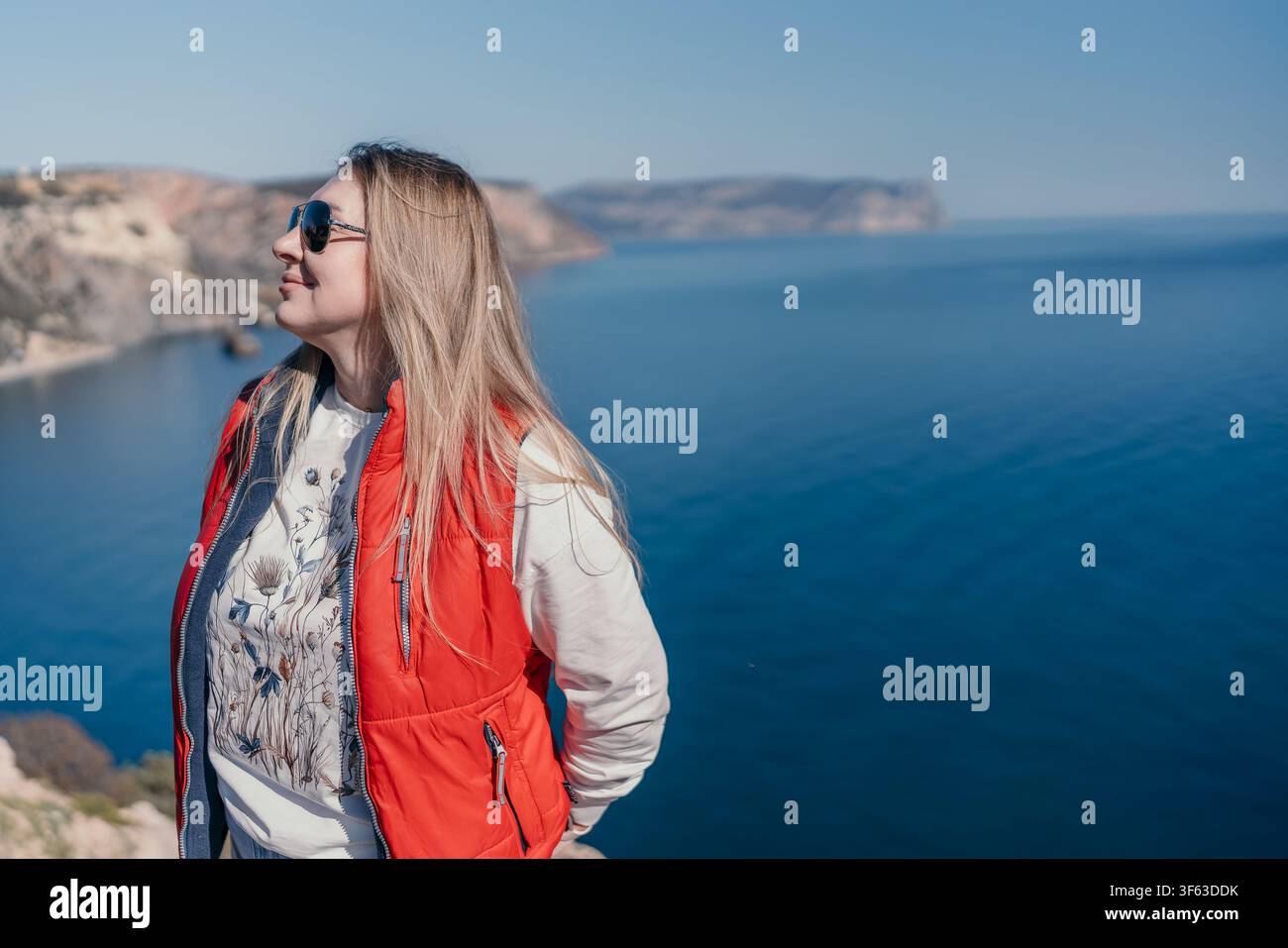 Donna sulla costa che guarda l'oceano blu da un'alta scogliera con spazio per il testo Foto Stock