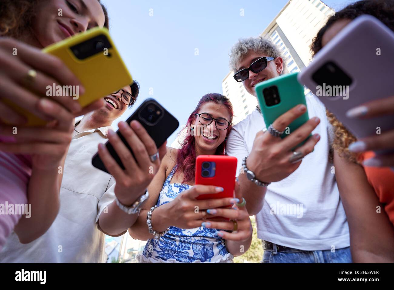 Le persone si sono collegate al telefono, ridendo e chiacchierando insieme in giro all'aperto. Foto Stock