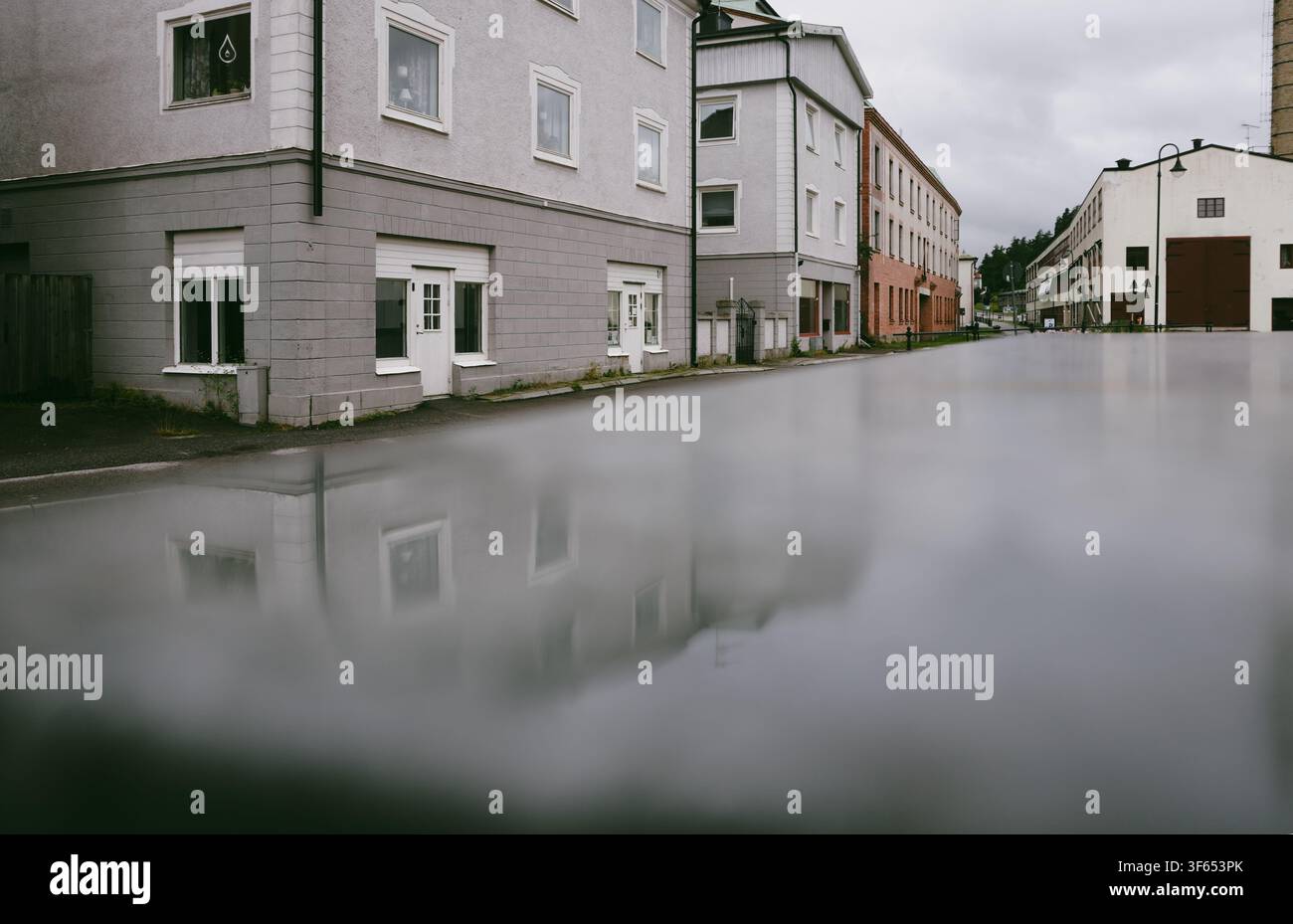 Edifici che si riflettono su una superficie bagnata Foto Stock