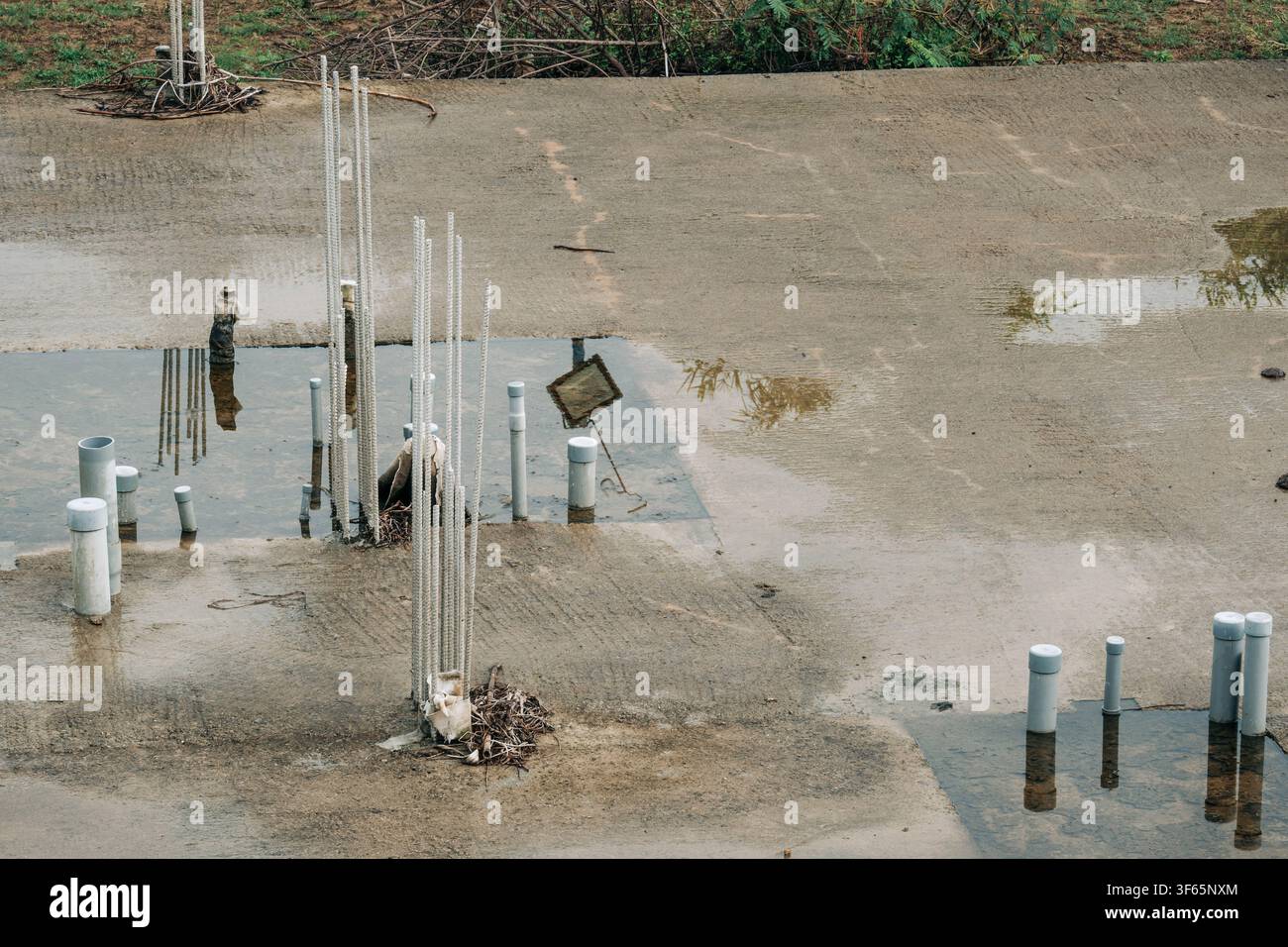 Fondazione in cemento incompiuta di un edificio con barre d'acciaio sporgenti Foto Stock