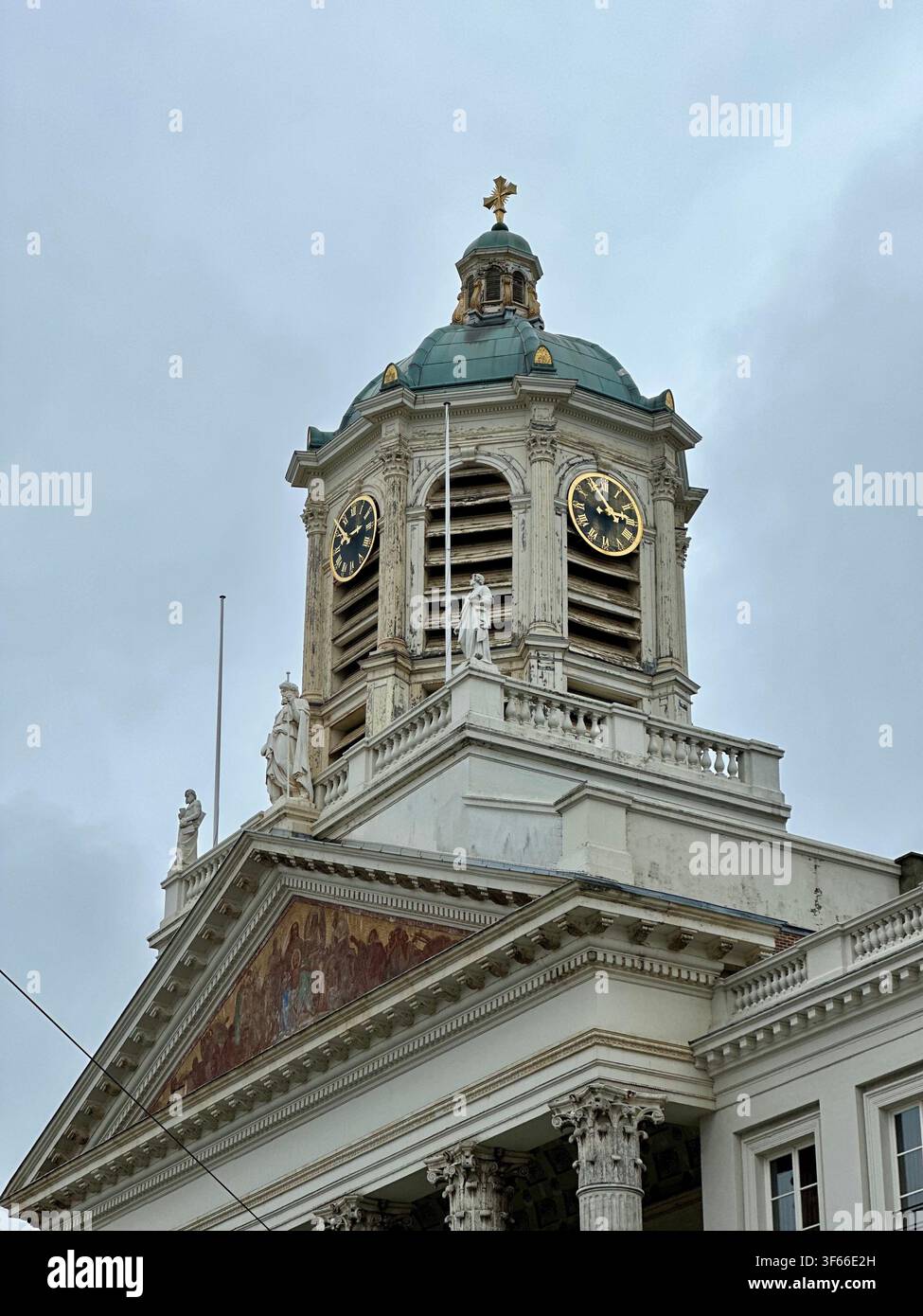 Torre campanaria storica con statue e cupola verde. Primo piano di una torre campanaria di chiesa europea classica con statue ornate, facciata orologio dorata - Immagine stock catturata con smartphone