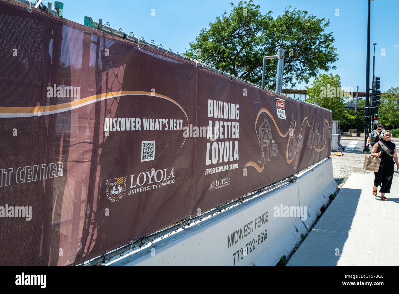 Recinzione per cantieri con striscioni promozionali per l'espansione del campus alla Loyola University Chicago a Rogers Park. Foto Stock