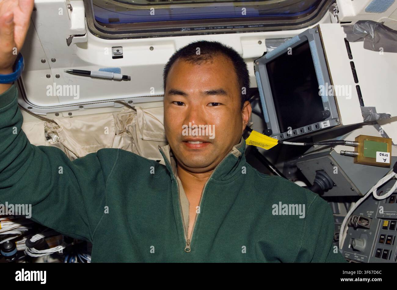 Soichi Noguchi, astronauta giapponese e specialista di missione sulla STS-114, sul ponte di volo con una bustina di bevanda. Foto Stock