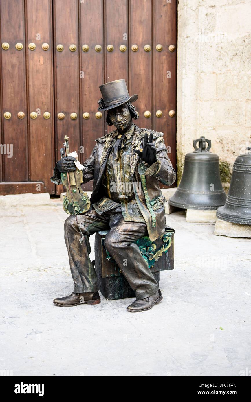 Personaggio mimo con cilindro, seduto su una scatola e con l'aspetto di una statua di bronzo all'Avana, Cuba Foto Stock