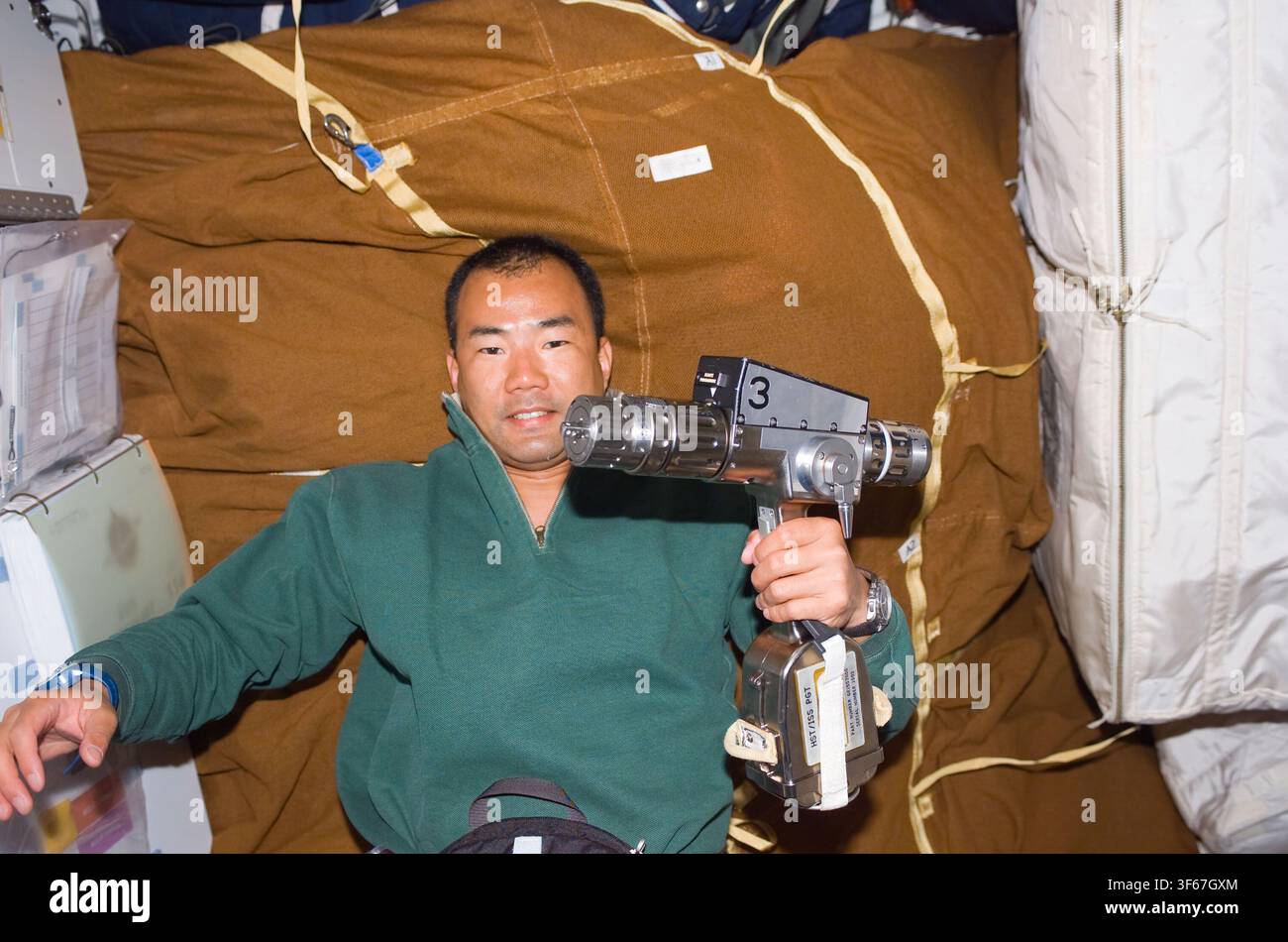 Soichi Noguchi, astronauta giapponese e specialista di missione della STS-114, con un utensile elettrico sul middeck dello Space Shuttle, durante la missione del 2005. Foto Stock