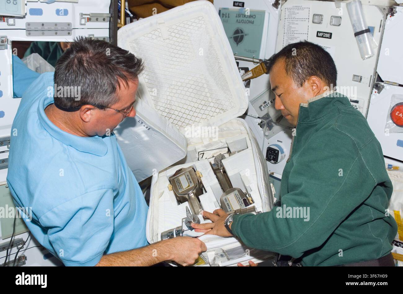 Soichi Noguchi e Stephen Robinson, specialisti di missione della STS-114, sul ponte intermedio durante il programma dello Space Shuttle. Foto Stock