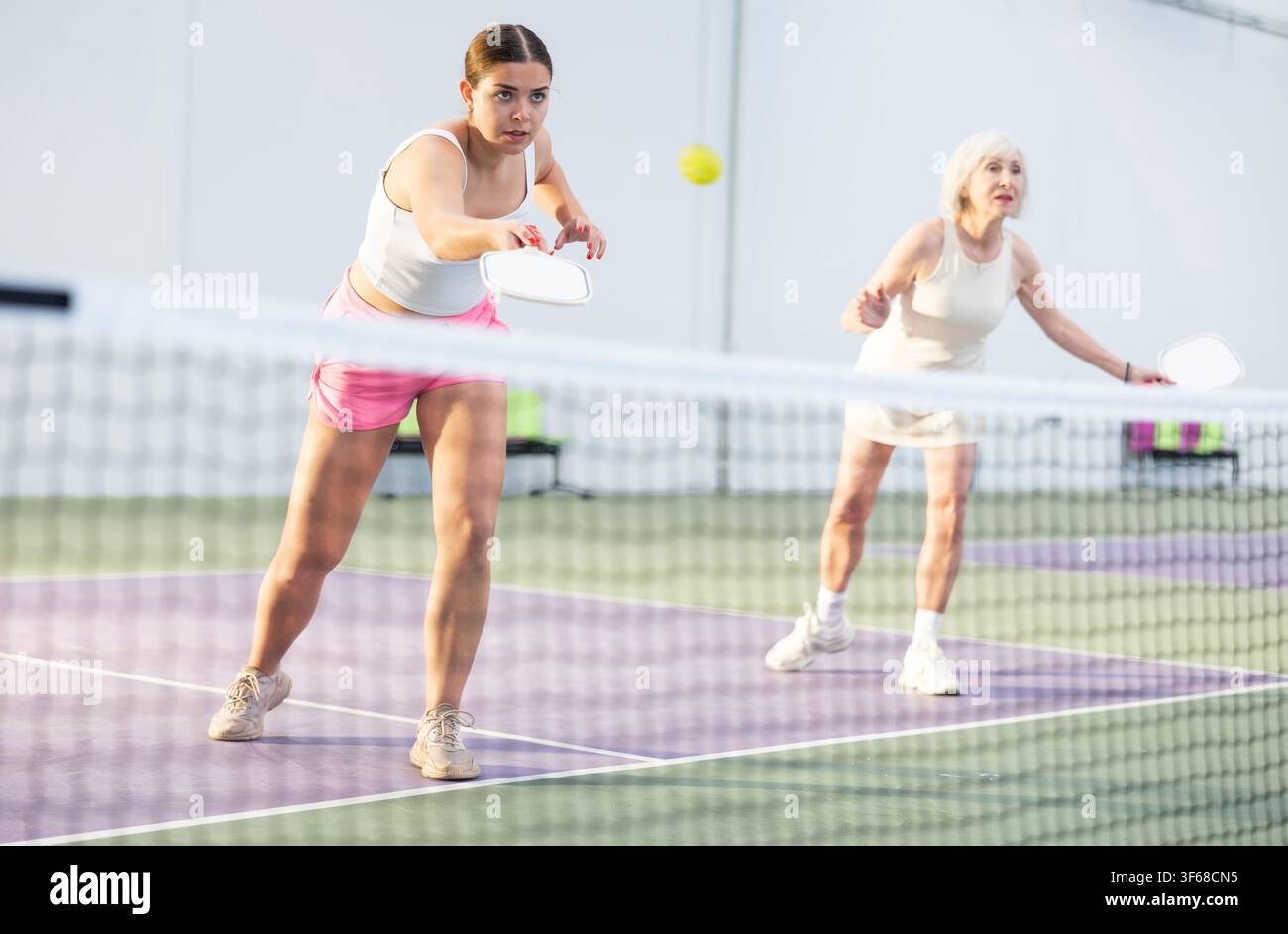 Donne che giocano a Pickleball tennis sul campo da Pickleball al coperto Foto Stock