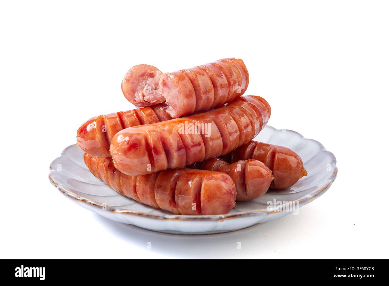 Pila di salsicce di maiale grigliate senza additivi con tagli a spirale su un piatto di ceramica, una rotta per mostrare la consistenza, isolata su sfondo bianco Foto Stock