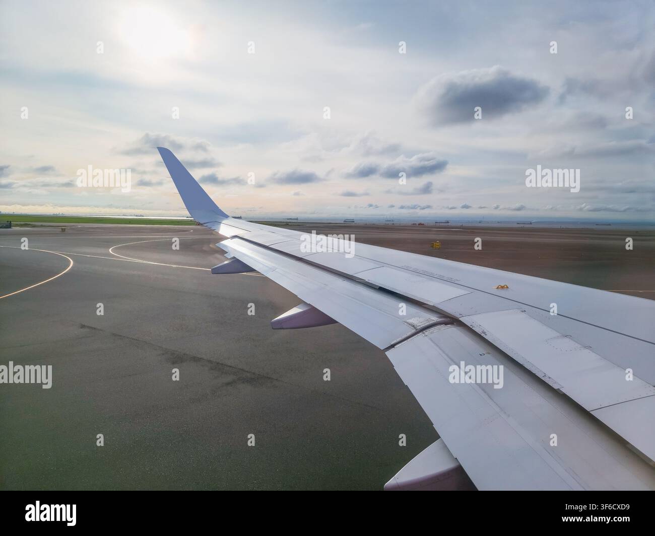 Vista dalla finestra di un aereo che mostra l'ala dell'aereo sulla pista dell'aeroporto di Haneda a Tokyo, Giappone. Foto Stock