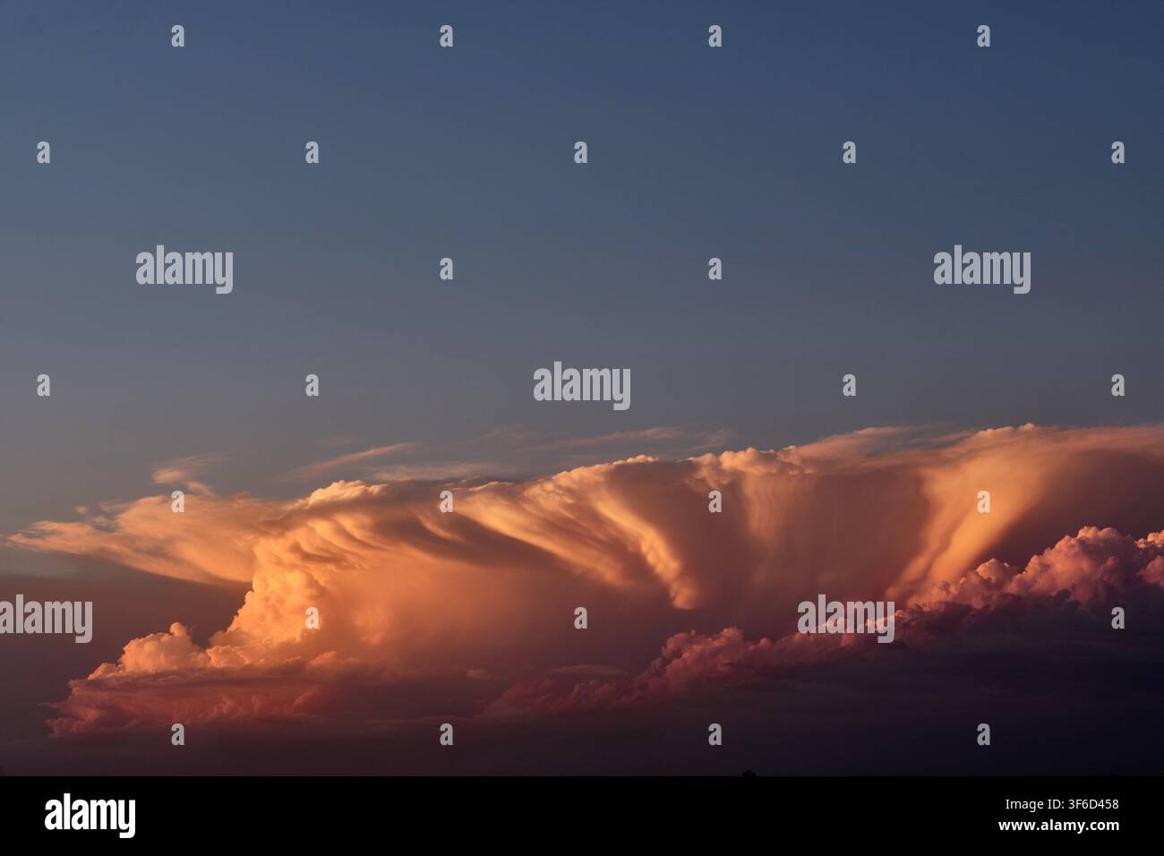 L'ultima luce del sole su un piccolo fronte temporalesco che si avvicina dopo il tramonto. Foto Stock