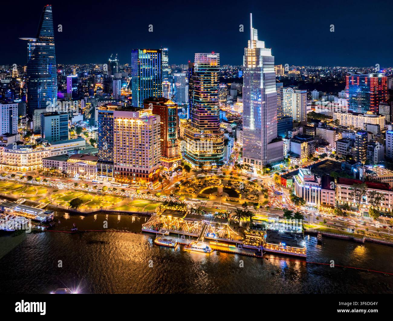 Vista aerea dello skyline illuminato di Ho Chi Minh City di notte con grattacieli moderni e luci sul lungofiume a Ho Chi Minh City, Ho Chi Min Foto Stock
