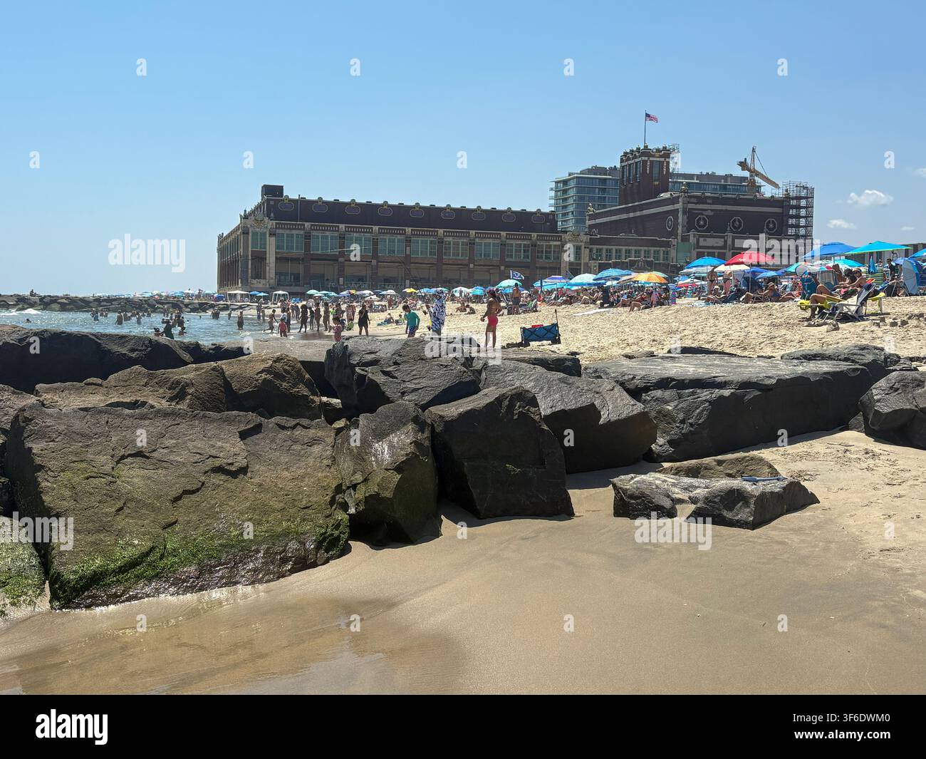 Asbury Park, New Jersey, USA - 26 luglio 2026: Le persone si godono la spiaggia ad Asbury Park con ombrelloni e onde visibili. Foto Stock