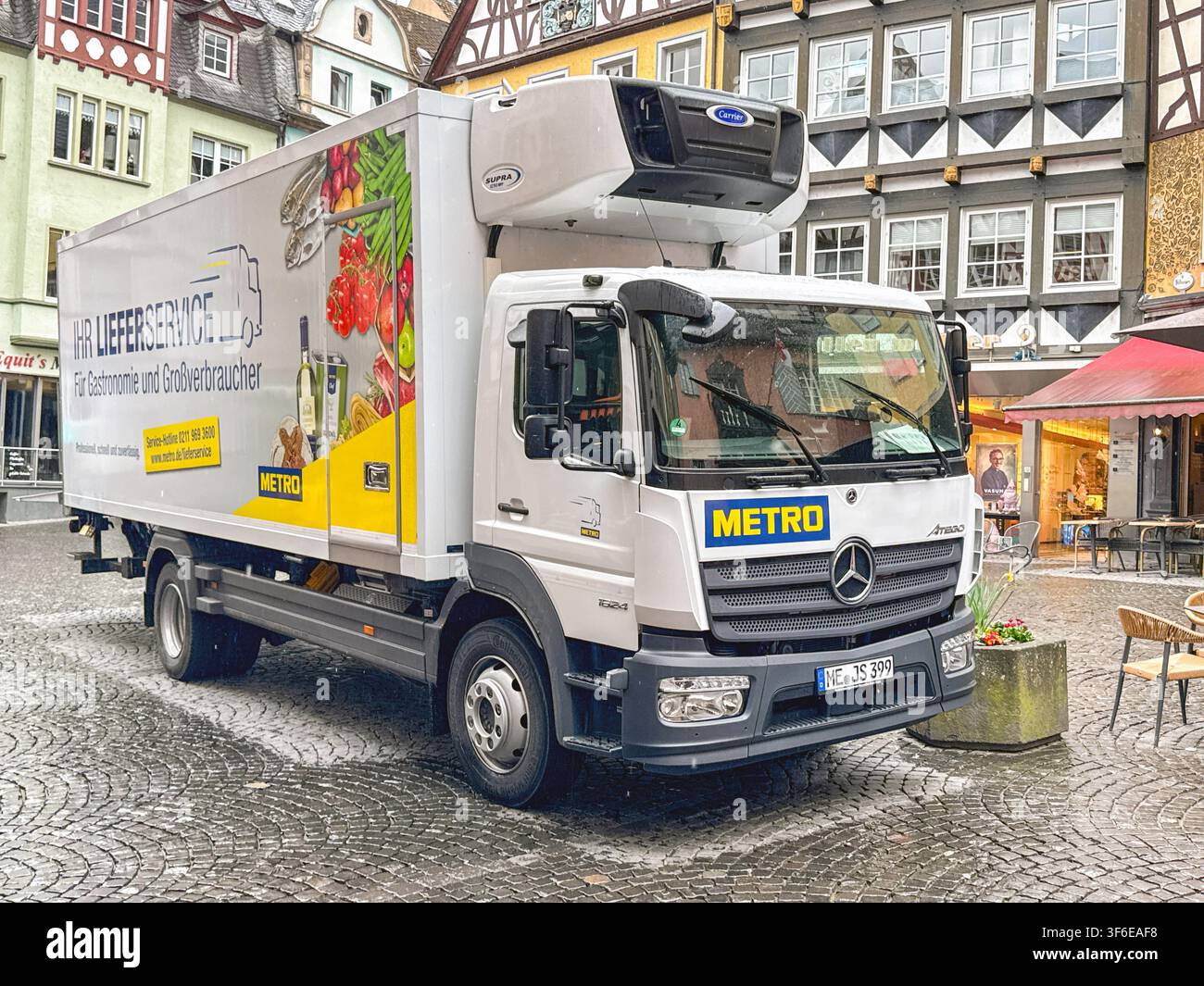 Cochem, Germania - 13 aprile 2026: camion di consegna gestito dal grossista Metro Germania fermo nella piazza del mercato di Cochem nella valle della Mosella - Immagine stock catturata con smartphone