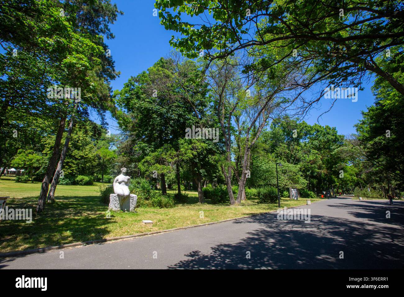 Sentiero verde lussureggiante e statua nel parco pubblico Sea Garden di Burgas, Bulgaria Foto Stock