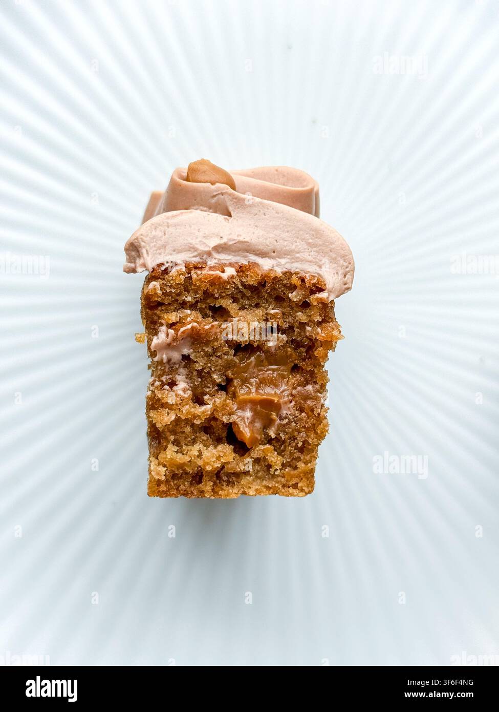 Eleganti mini panini decorati con onde di crema al cioccolato, gocce di caramello e briciole croccanti Foto Stock