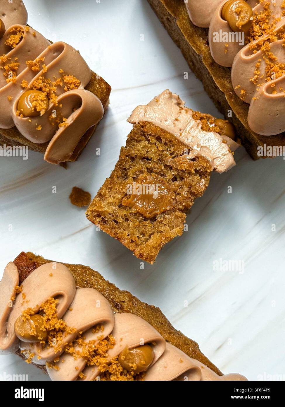 Eleganti mini panini decorati con onde di crema al cioccolato, gocce di caramello e briciole croccanti Foto Stock