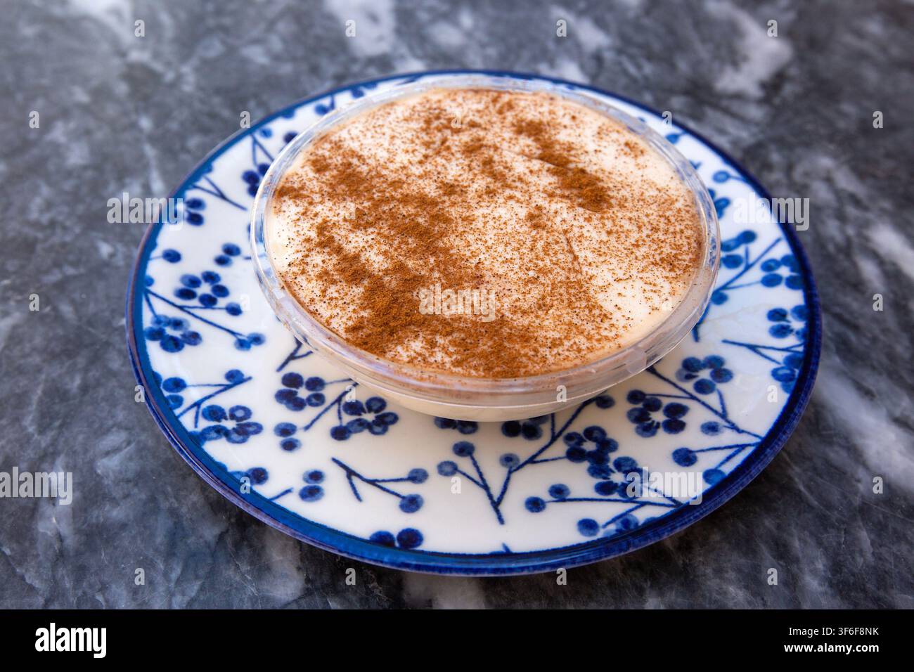 Riso al latte tradizionale turco Sutlac con polvere di cannella su piatto decorato Foto Stock