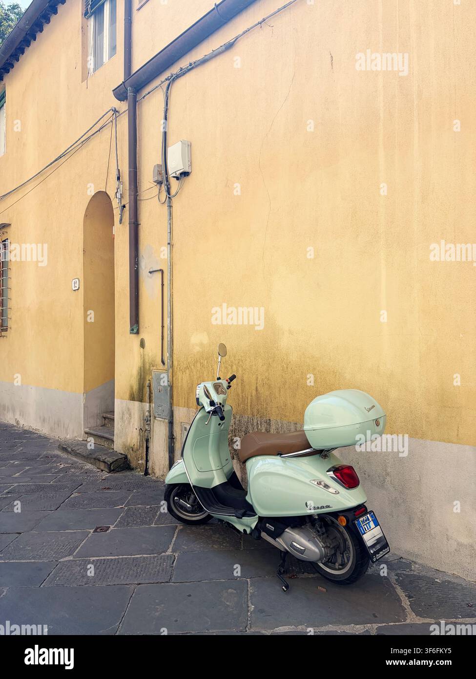 Lucca, Italia – 5 agosto 2026: Scooter Vespa classico in un vicolo stretto del centro storico. Foto Stock