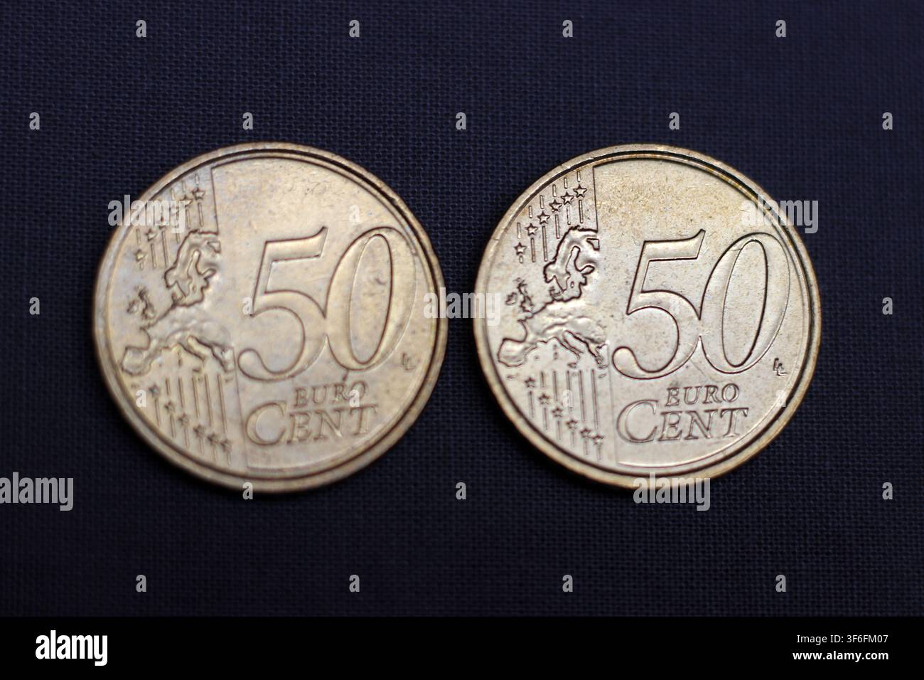 Due monete da 50 centesimi di euro su sfondo scuro Foto Stock