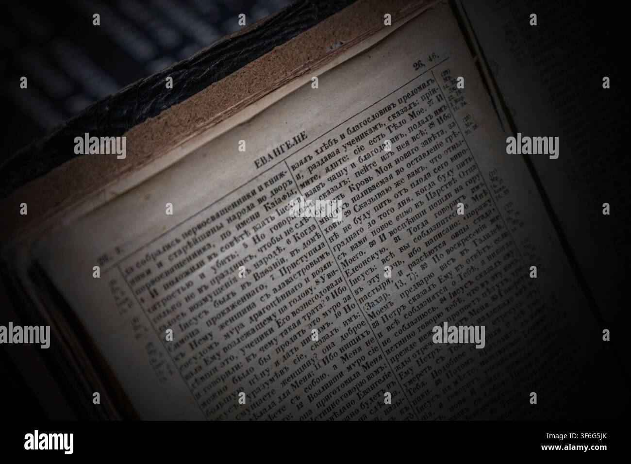 Un libro antico rilegato in pelle aperto su pagine che mostrano testo russo, specificamente un passaggio intitolato Vangelo. La pagina contiene versetti numerati del Foto Stock