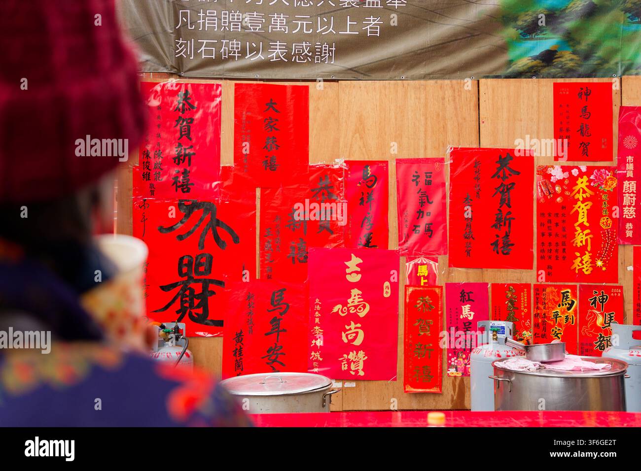 Nuova Taipei, Taiwan - 17 feb 2026: Primo piano di couplet del Capodanno lunare rossi di politici posti al tempio Luzhou Baohe, auguri festivi Foto Stock